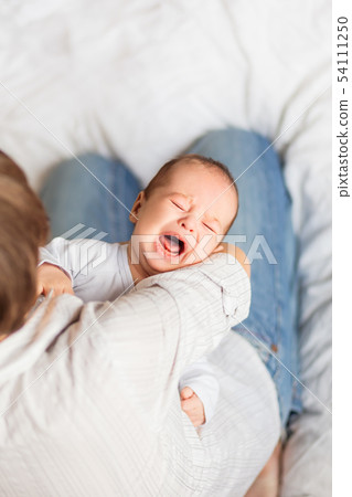 Woman Holding A Crying Child Mother And Baby Stock Photo