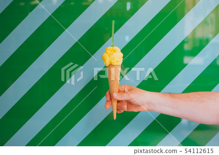 Ice cream in a hand of man. Ice cream in a hand of man. 54112615