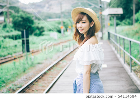 Woman waiting for a train at a rural station Woman waiting for a train at a rural station 54114594