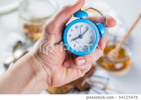 Morning alarm concept - hand with clock Morning alarm concept - hand with clock 54115478