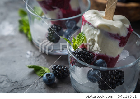 Berry popsicles on rustic background Berry popsicles on rustic background 54115511