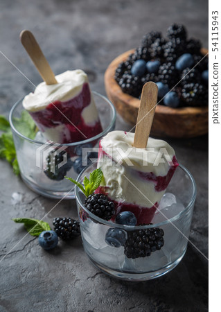 Berry popsicles on rustic background Berry popsicles on rustic background 54115943