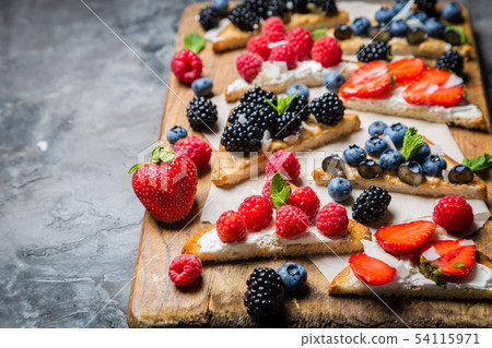 Selection of toasts with cheese peanut butter and berries 54115971