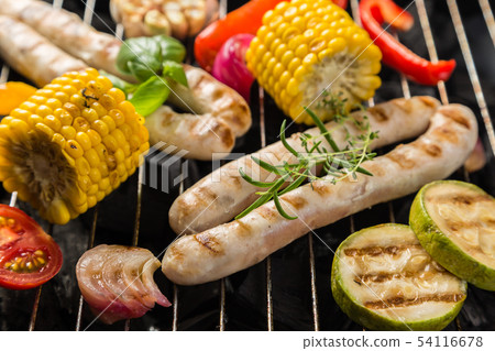 Preparing grilled sausage and vegetables Preparing grilled sausage and vegetables 54116678