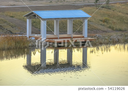 Roofed deck reflected on Oquirrh Lake in Utah 54119026