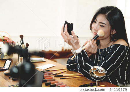 asian woman applying makeup cosmetic asian woman applying makeup cosmetic 54119579