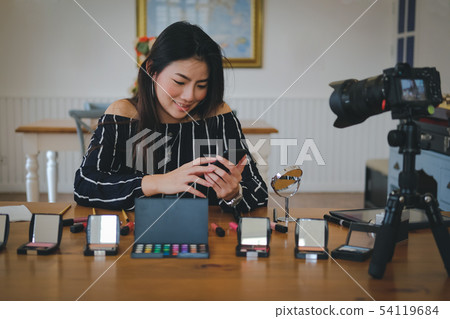 beauty blogger live broadcasting cosmetic makeup tutorial on social media. 54119684