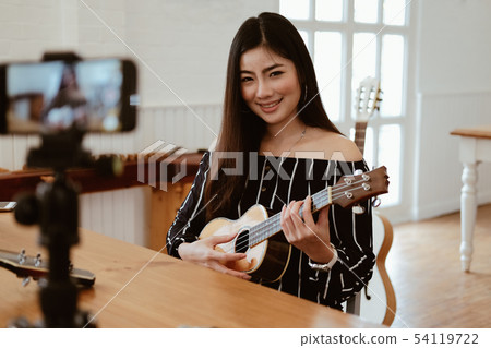 blogger live broadcasting music instrument tutorial on social media. vlogger recording online vlog video. 54119722