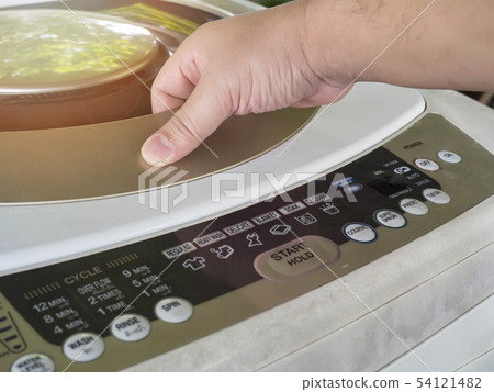 Man open the washing machine door he doing Laundry 54121482