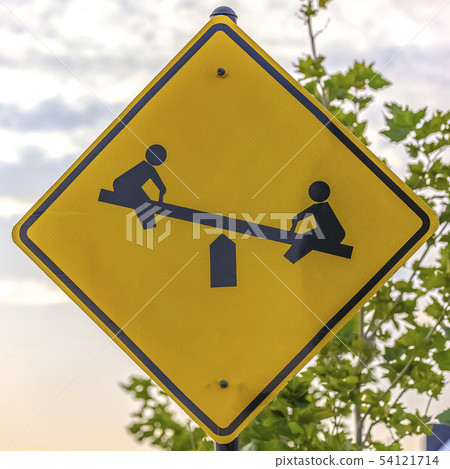 Playground sign with image of children on seesaw 54121714