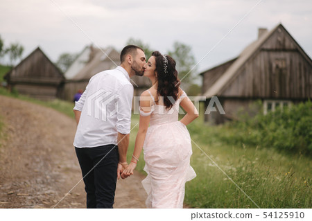Groom kiss his beautiful bride. Couple walking in mountains Groom kiss his beautiful bride. Couple walking in mountains 54125910