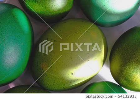 Green Easter eggs on a white platter.  54132935