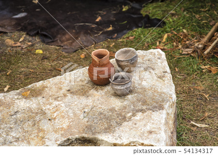 Ancient cray pots on the rock. Against the skin. 54134317