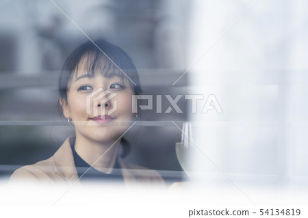 一個年輕的女人,從咖啡店裡面看起來很平靜,看起來很清醒 一個年輕的女人,從咖啡店裡面看起來很平靜,看起來很清醒 54134819