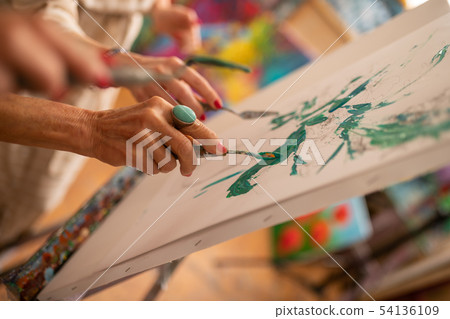 Artist holding painting pallet with gouache while coloring picture 54136109