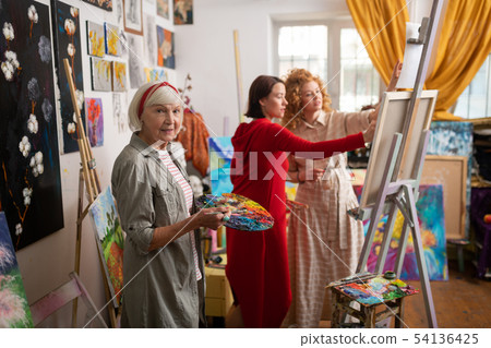 Art teacher mixing gouache standing near students 54136425