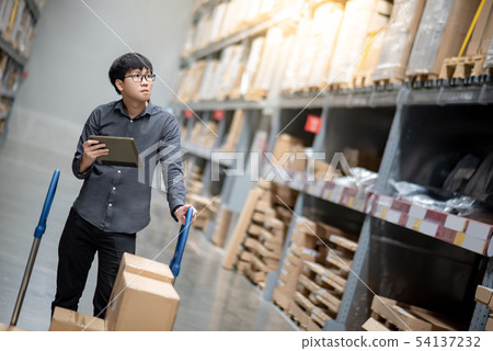 Asian man doing stocktaking on tablet in warehouse Asian man doing stocktaking on tablet in warehouse 54137232