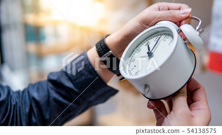 Male hand adjusting the time on white clock Male hand adjusting the time on white clock 54138575