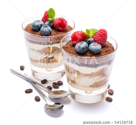 Classic tiramisu dessert with blueberries and raspberries in a glass isolated on a white background 54138716
