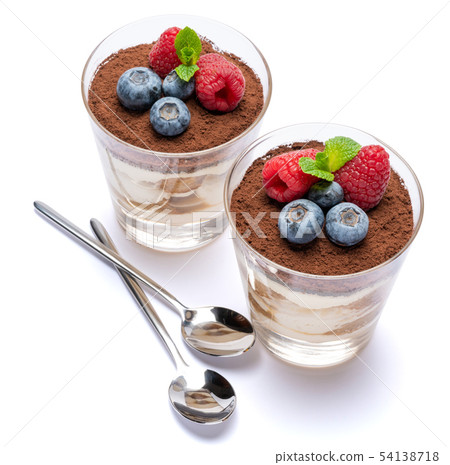 Classic tiramisu dessert with blueberries and raspberries in a glass isolated on a white background Classic tiramisu dessert with blueberries and raspberries in a glass isolated on a white background 54138718