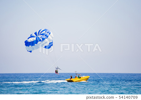 Photographer making a photo of couple of tourists flying on a parachute 54140709