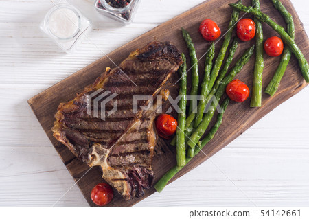 Grilled T-bone steak with asparagus and cherry Grilled T-bone steak with asparagus and cherry 54142661