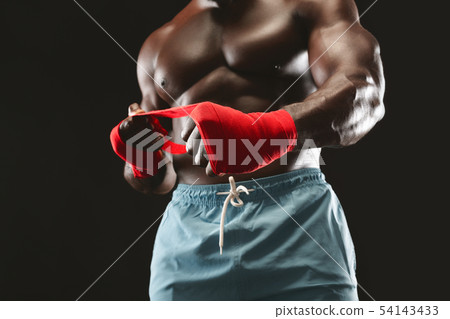 Strong african man wrapping hands with boxing wraps 54143433