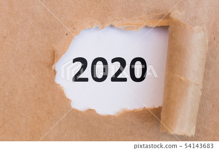 Close up of 2020 black text under torned brown paper 54143683