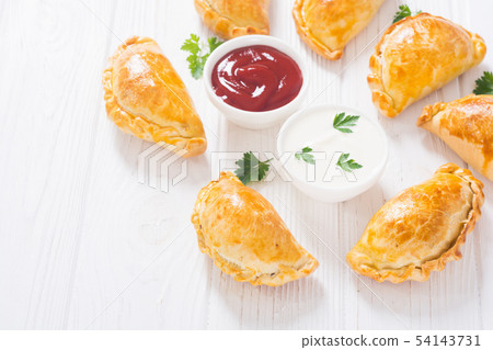 Latin American baked beef empanadas with sauce 54143731
