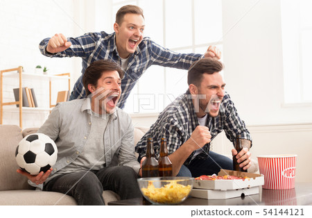 Excited friends watching football match and shouting 54144121
