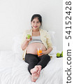 Asian pregnant woman drinking orange juice and 54152428