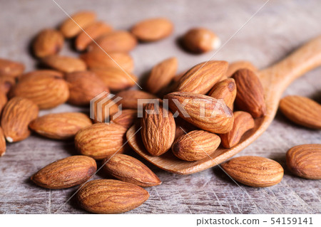 Almond nuts in wooden spoon on rustic background. Almond nuts in wooden spoon on rustic background. 54159141