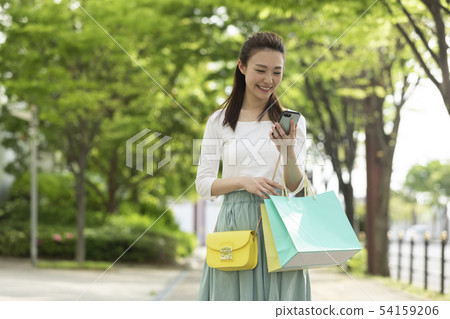 A woman walking while making a phone call A woman walking while making a phone call 54159206