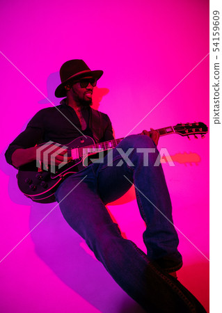 Young african-american jazz musician playing the guitar Young african-american jazz musician playing the guitar 54159609