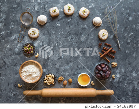 Egg, flour and nuts are laid out a dark background Egg, flour and nuts are laid out a dark background 54162997