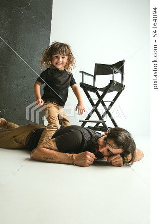 Father playing with young son in their sitting room 54164094