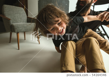 Father playing with young son in their sitting room Father playing with young son in their sitting room 54164346