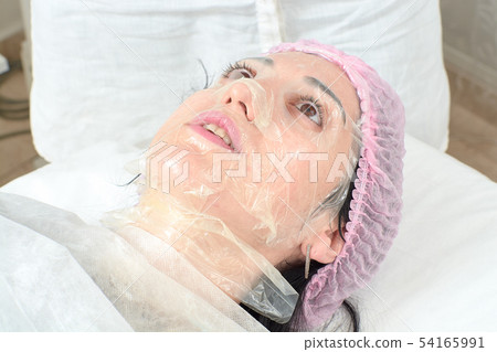 Young woman in beauty salon doing peeling and Young woman in beauty salon doing peeling and 54165991
