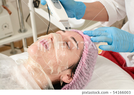 Young woman in beauty salon doing peeling and Young woman in beauty salon doing peeling and 54166003