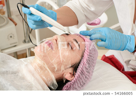 Young woman in beauty salon doing peeling and Young woman in beauty salon doing peeling and 54166005