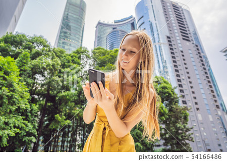 Woman Tourist using navigation app on the mobile phone. Navigation map on a smartphone in a big city 54166486
