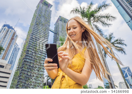 Woman Tourist using navigation app on the mobile phone. Navigation map on a smartphone in a big city Woman Tourist using navigation app on the mobile phone. Navigation map on a smartphone in a big city 54166998
