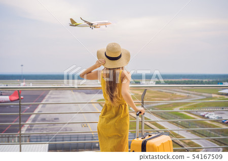 Start of her journey. Beautiful young woman ltraveler in a yellow dress and a yellow suitcase is Start of her journey. Beautiful young woman ltraveler in a yellow dress and a yellow suitcase is 54167509