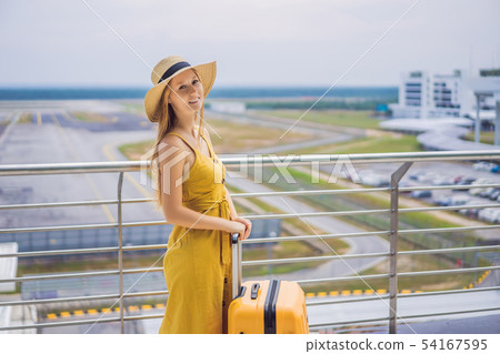Start of her journey. Beautiful young woman ltraveler in a yellow dress and a yellow suitcase is Start of her journey. Beautiful young woman ltraveler in a yellow dress and a yellow suitcase is 54167595