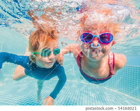 Kids having fun playing underwater in swimming pool on summer vacation Kids having fun playing underwater in swimming pool on summer vacation 54168021