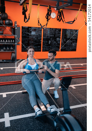 Athletic trainer helping his overweight client working out Athletic trainer helping his overweight client working out 54172014