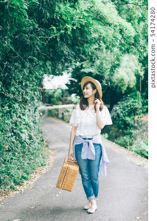 A woman walking along a country road A woman walking along a country road 54174280
