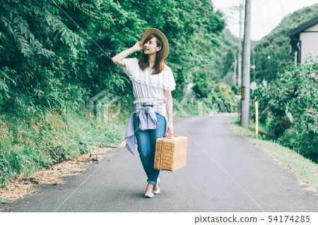 A woman walking along a country road A woman walking along a country road 54174285