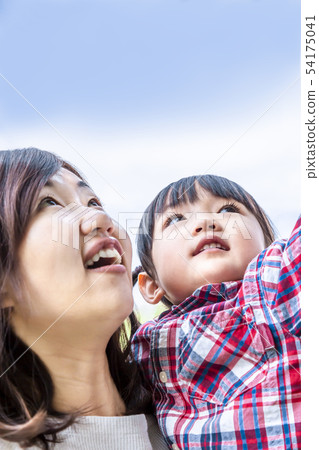 Little girl staring at the top with mother against the blue sky. Happiness, hope image 54175041