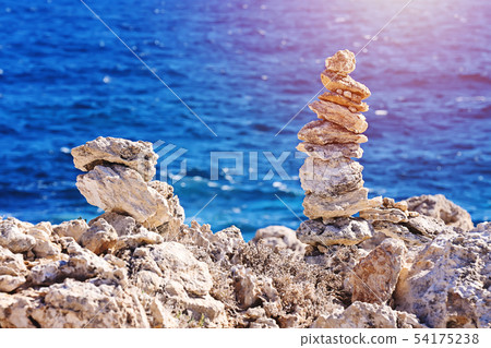 Zen pyramid of stacked rough stones on blurred sea background 54175238